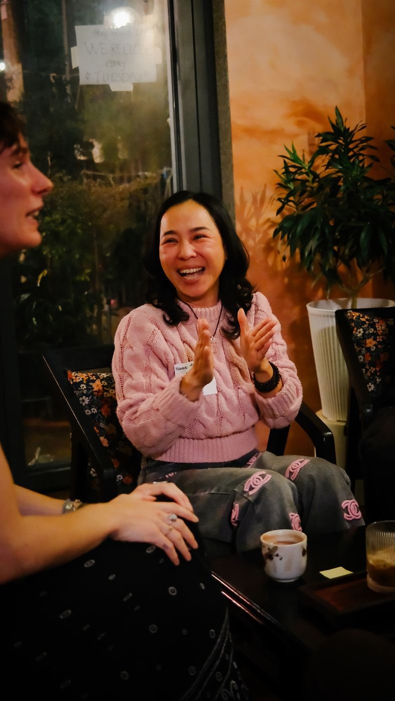 Guest laughing in a pink sweater